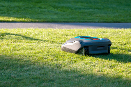 Smart robotic mower cutting grass on sunny dayの写真素材
