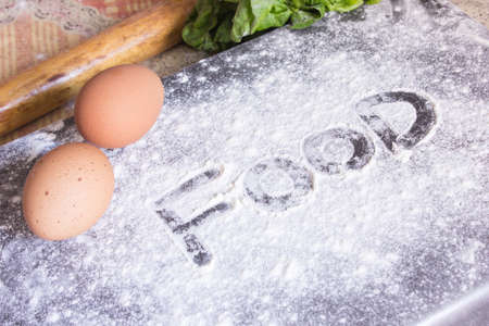 Bakery flour and leafy greens and wood rolling pin and tow egesの写真素材