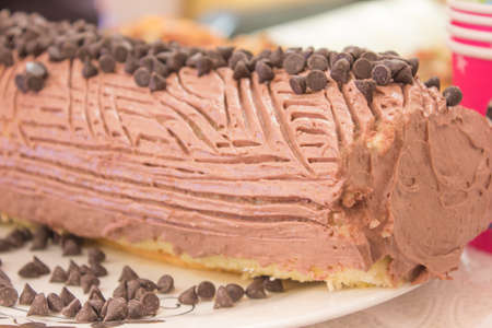 Cake with chocolate balls and red cup on white plateの写真素材