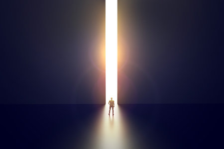 Businessman walking towards bright opening in concrete wall. Opportunity and success concept.の写真素材