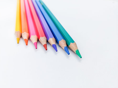Arrangement of colored pencils against white background