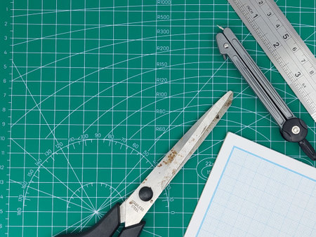 Directly high angle shot of paper, cutting mat, ruler, scalpel and scissors