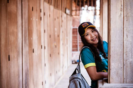 portrait of a beautiful asian woman traveller in front of old house buildingの写真素材