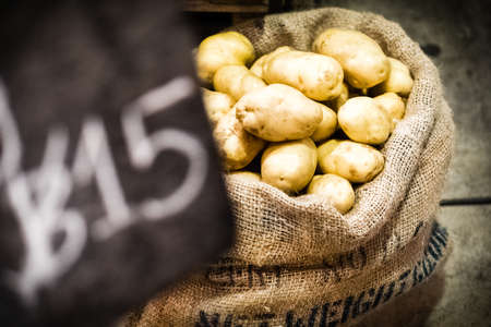 fresh potatoes in burlap sack selling in marketの写真素材