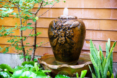 Fountain bali-style earthenware jar in gardenの写真素材