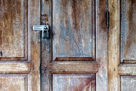 Old padlock on a wooden doorの写真素材