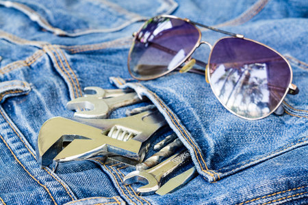 Tools in Jeans pocket with sunglasses background concept