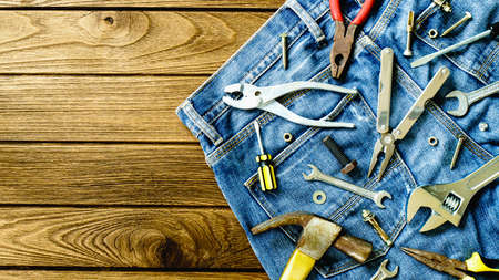 Construction tools and jeans on wooden backgroundの写真素材