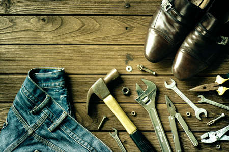 Construction tools, shoes and jeans on wooden backgroundの写真素材