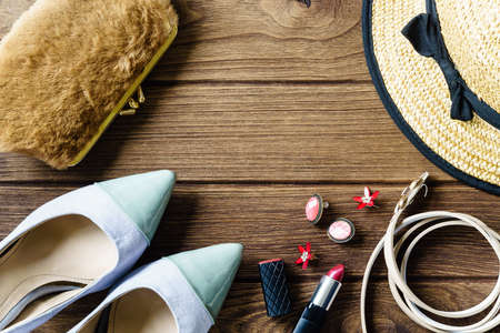 women's accessories - bag, heels, earrings, lipstick on wooden background, top viewの写真素材