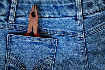 Wire cutting pliers in jeans pocket concept and background for labor daysの写真素材