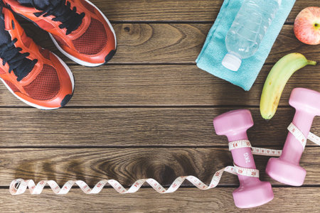 Fitness, healthy and active lifestyles Concept, dumbbells, sport shoes, bottle of waters, banana and...