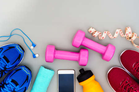 Fitness, healthy and active lifestyles Concept, dumbbells, sport shoes, bottle of waters, smartphone with headphone on grey background. copy space for text. Top viewの写真素材