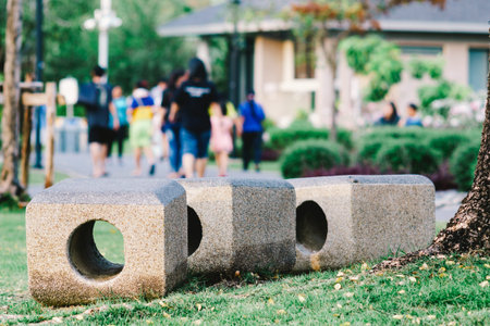Stone bench in the park with people are moving away in the background. Abstract background in film tone.の写真素材
