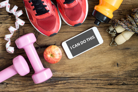 Fitness, healthy and active lifestyles Concept, dumbbells, sport shoes, bottle of waters,...