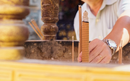 Man sticks an incense sticks in Incense burner at chinese temple in Bangkok to worship the god...