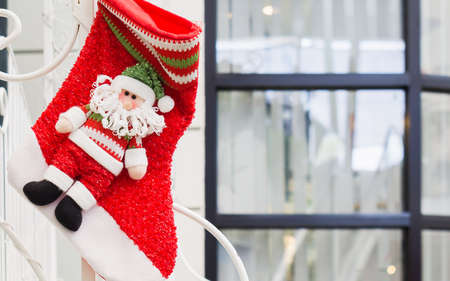 Christmas decoration red stocking and cute red santa claus toys hanging for xmas themeの写真素材