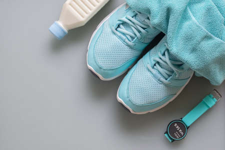 Fitness, healthy and active lifestyles Concept, sport shoes, smart watch, bottle of milk, towels on grey background. top view with blank copy spaceの写真素材