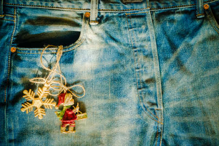 Gold snowflake and cute christmas dolls christmas decoration in old grunge vintage denim jean pocket, merry christmas and happy new year fashion greeting card background conceptの写真素材