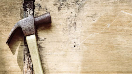 Old rusted hammer on grunge rough surface wood, Rustic and retro style. top view with copy space, labor day background concept.の写真素材