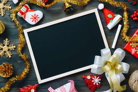 Christmas Xmas New Year holiday background with empty black chalkboard for your text and various festive decorations. blank chalkboard surrounded of christmas items top view with copy spaceの写真素材