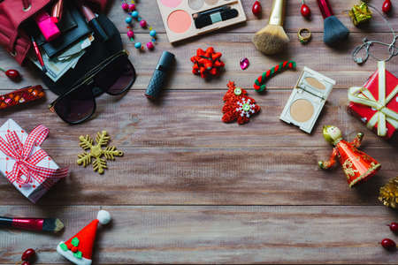 Still life flat lay of colorful makeup cosmetic with Christmas decoration on wood background top view with copy space, Chistmas and Happy new year fashion cosmetics background concept.の写真素材