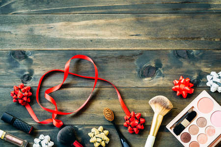Still life flat lay of colorful makeup cosmetic with bows on wood background top view with copy space, Valentines, Chistmas, Happy new year and any anniversary holidady fashion cosmetics background concept.の写真素材