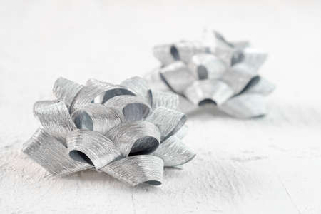 Close up of two silver color decorational ribbon gift bows, anniversary background conceptの写真素材