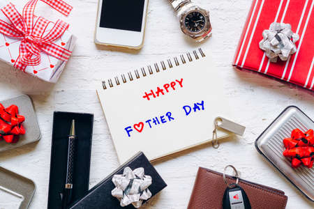 Happy Father's Day background concept. Set of men's clothing and accessories.  Wallet, watch, mobile phone, car key ,pen and gifts on grungy white wooden table background. Top view with copy space.の写真素材
