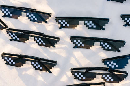 Group of funny sun eyeglasses selling in the market on the canvas background with sun lightの写真素材
