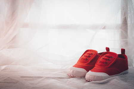 Still life close up little baby red shoes with lovely morning windows sun light abstract background...
