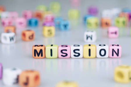 Mission word text written on colorful cube with bokeh cube word block backgroundの写真素材