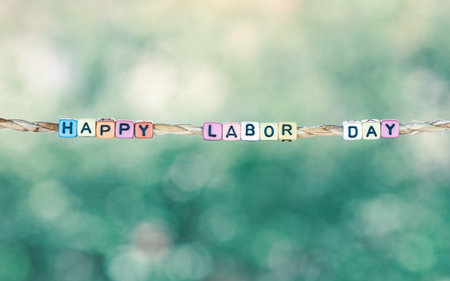 Happy Labor Day word hanging by rope with beautiful green nature bokeh background, retro vintage...