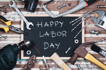 Chalk board with text HAPPY LABOR DAY with variety gruge rusty handy tools on a rusty wooden table.の写真素材