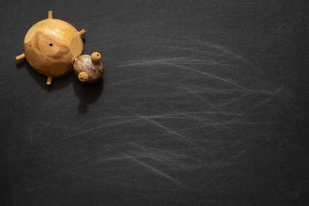 Cute turtle toys on black chalkboard with blank copy space, ideal for preschool, education, or back to school background  conceptsの写真素材