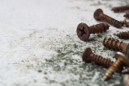 Close up selective focus of rusty screws. old steel bolts on grungy white wood background
