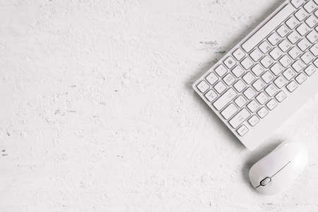 White computer keyboard and wireless mouse on the rusty white desk office wooden. Top view office equipment with copy space.の写真素材