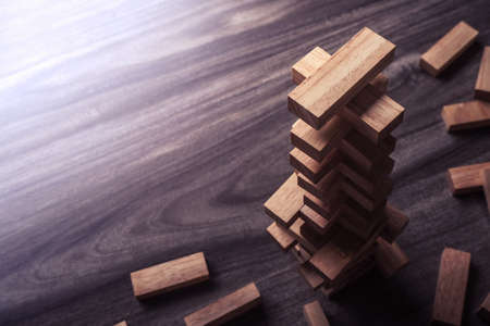 Wooden building blocks tower on wooden background top view with copy space. Wood blocks stack game background concept for business risk, education, building, development, and growthの写真素材