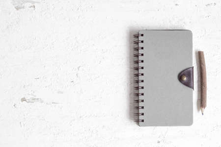 Flat lay of closed notebook with blank cover on the rusty white wooden table. View from above with copy space for banner template and mockup.の写真素材