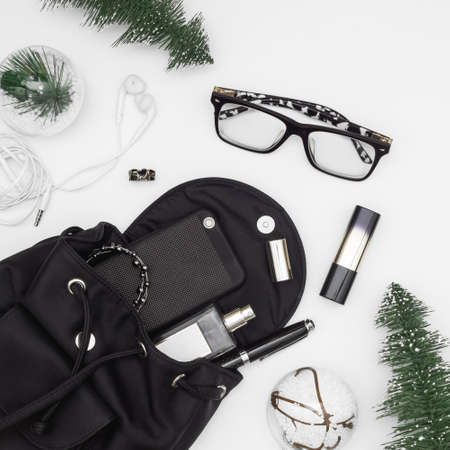 Merry Christmas and Happy newyear beauty and fashion concept. Flat lay of Christmas ornaments and black woman bag open out with accessories, smartphone on grunge white background.の写真素材
