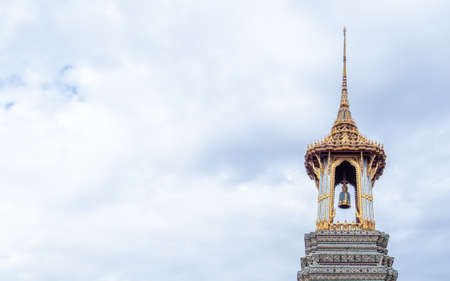 The ancient bell tower (Belfry) at Wat Phra Kaew (Temple of the Emerald Buddha) and grand palace on a cloudy dayの写真素材