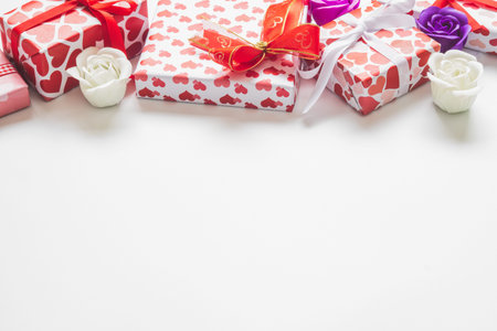 Valentine day background with gift boxes with hearts shape paper wrapper and roses on white...