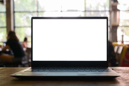 Laptop with blank screen on table with blurred coffee shop  background.の写真素材