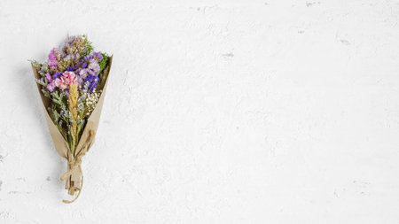 Beauty bouquet of dried flowers on rusty white background, top view with copy space