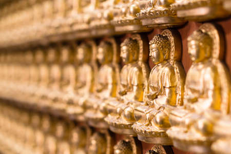 Wall in temple made by thousand of small golden Buddha statue at Chinese temple named the Wat Borom Raja Kanjanapisek (Wat Leng Neur Yee 2) in Thailandの写真素材