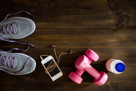 Fitness, healthy and active lifestyles Concept, dumbbells, running shoes, bottle of milk, smartphone...