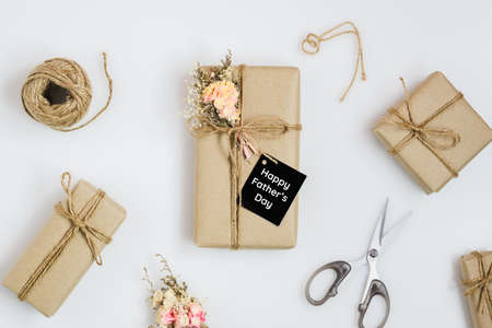 Father's day concept. DIY hand mand Fathers Day gifts with tag Happy Father's Day with beautiful natural flower bouquet on white background. Greetings and presents.の写真素材