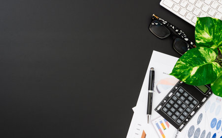 Flat lay office desktop work space of wireless keyboard, report graph and charts, pen, calculator...