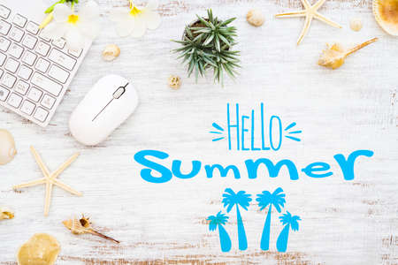 Hello summer travel vacation planning concept. Flat lay summer holiday poster background concept. Hello Summer text on white wood background, wireless mouse keyboard with colorful tropical palm leaf, seashell and starfish.の写真素材