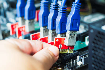 Close-up hand plug a cable to slot for build a equipment for mining cryptocurrencyの写真素材